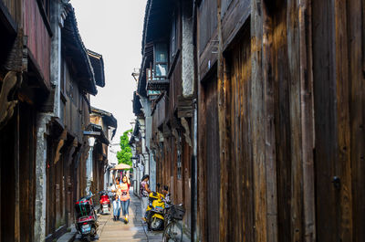 People walking on street amidst buildings in city