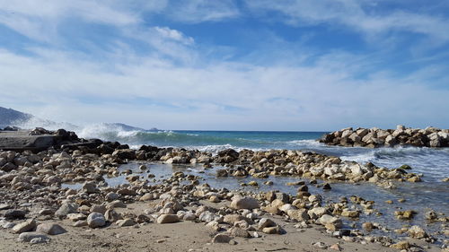 Rocks on beach against sky