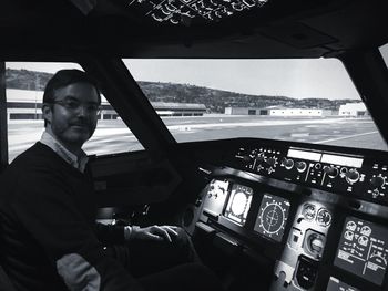 Portrait of mature man sitting at cockpit in airplane