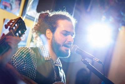 Close-up of young man singing on stage