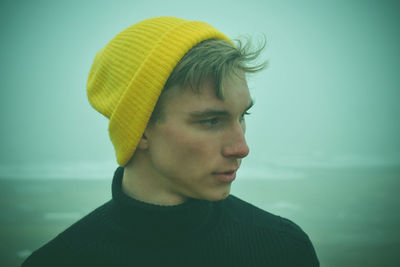 Close-up of man wearing knit hat looking away