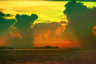 Scenic view of sea against dramatic sky during sunset