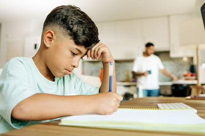 Homeschooling and freelancing. happy child son giving high five to mother while doing homework