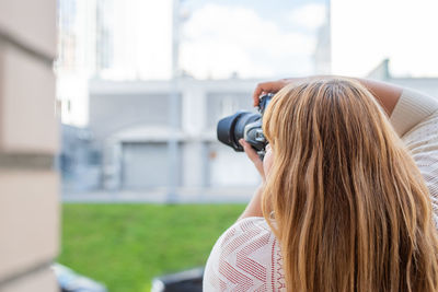 Rear view of woman photographing outdoors