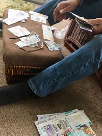 Low section of man holding paper while sitting outdoors