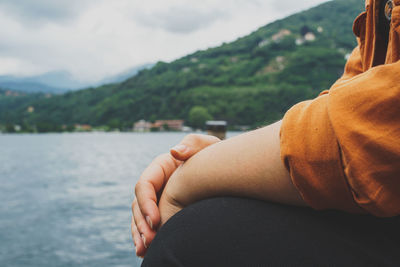 Low section of woman against lake