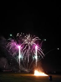 Low angle view of firework display against sky at night