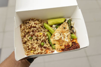 Cropped hand holding box with rice