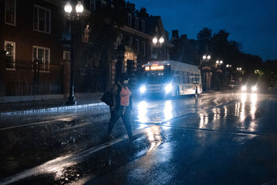 Illuminated city street during rainy season at night