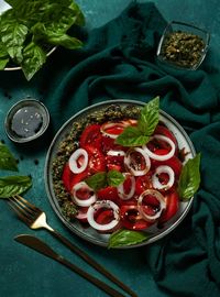 Tomato salad with sweet onion, pesto sauce and balsamic sauce, high angle view 
