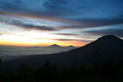 Scenic view of silhouette mountains against sky at sunset