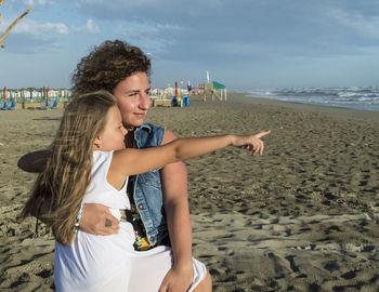 Happy young woman on beach against sky