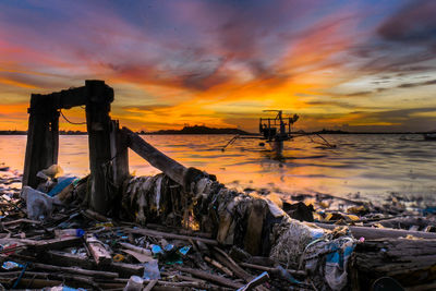 Abandoned built structure by sea against sky during sunset