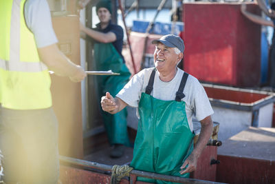 Fisherman on trawler talking to inspector