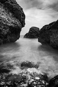 Rocks in sea against sky