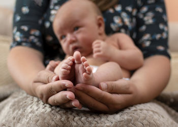 Baby boy lying on mothers arm