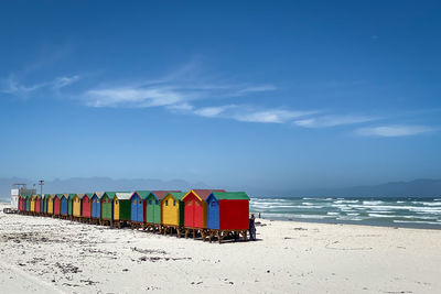 Multi colored chairs on beach against sky