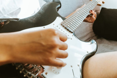 Midsection of person playing guitar