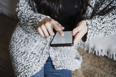 Midsection of woman using mobile phone