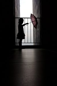 Silhouette woman standing against wall