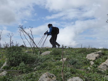 Man working on plants against sky