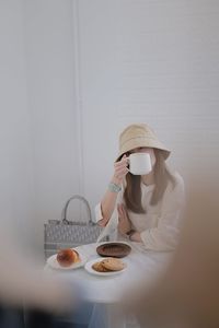 Portrait of woman holding coffee cup sitting at cafe