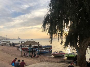 People at beach against sky