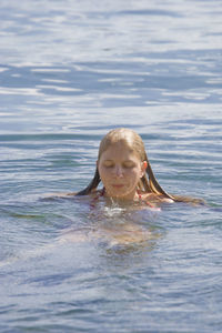 Happy girl swimming in sea