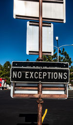 Low angle view of information sign against sky