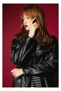 Young woman standing against gray background