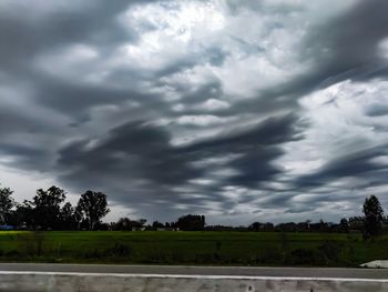 Scenic view of field against cloudy sky