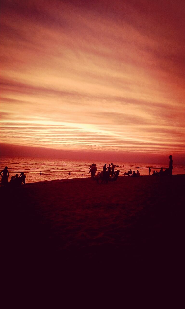 sunset, sky, beach, silhouette, sea, orange color, scenics, beauty in nature, water, large group of people, tranquil scene, cloud - sky, tranquility, horizon over water, nature, shore, medium group of people, idyllic, leisure activity