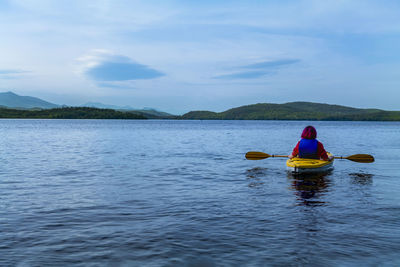 Woman kayaking. rear view of a young woman splashing water while kayaking on river person
