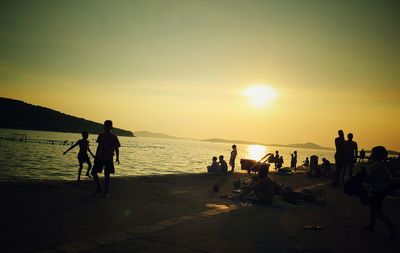 Silhouette of people at beach during sunset