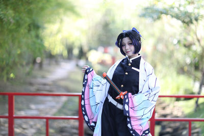 Portrait of young woman standing in park