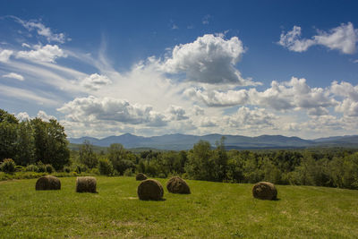 Hay bales on field against sky