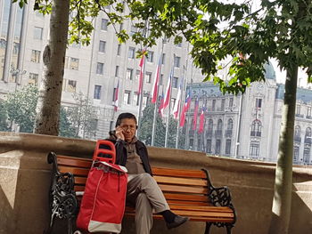 Portrait of smiling man on bench against plants