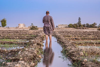 Rear view of a man walking on countryside landscape