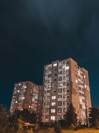 Low angle view of illuminated skyscraper against sky at night