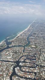 High angle view of townscape by sea against sky