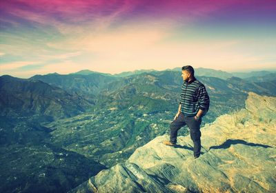 Full length of woman standing on mountain against sky