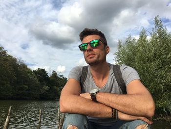 Low angle view of man wearing sunglasses looking away against sky