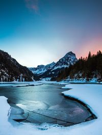 Scenic view of frozen lake against sky during winter