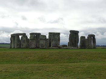Castle on field against cloudy sky