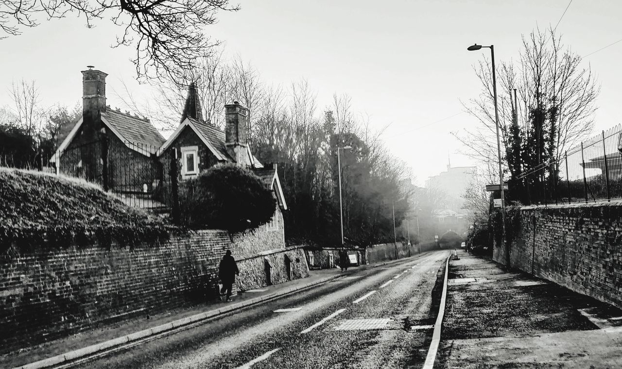 ROAD BY BUILDING AGAINST SKY