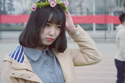 Close-up of young woman looking away while wearing flowers