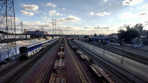 Railroad tracks against cloudy sky