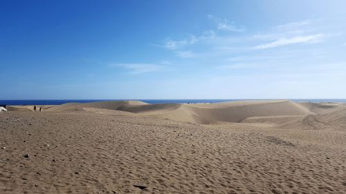 Scenic view of beach against blue sky