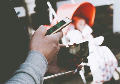 Cropped image of hand holding smart phone