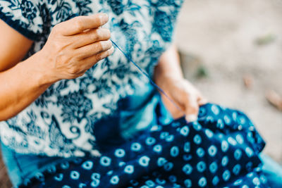 Midsection of woman knitting cloth